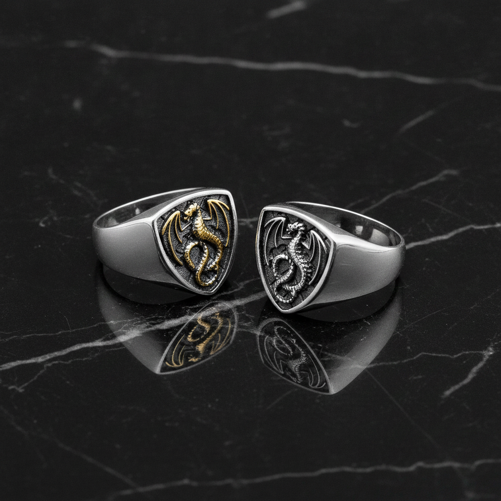 Two dragon-themed rings on a dark marble surface