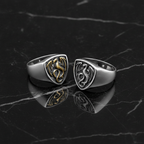 Two dragon-themed rings on a dark marble surface