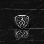 Silver dragon emblem ring on a dark marble surface