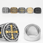 Collection of silver, gold, and black rings with religious symbols on a white background