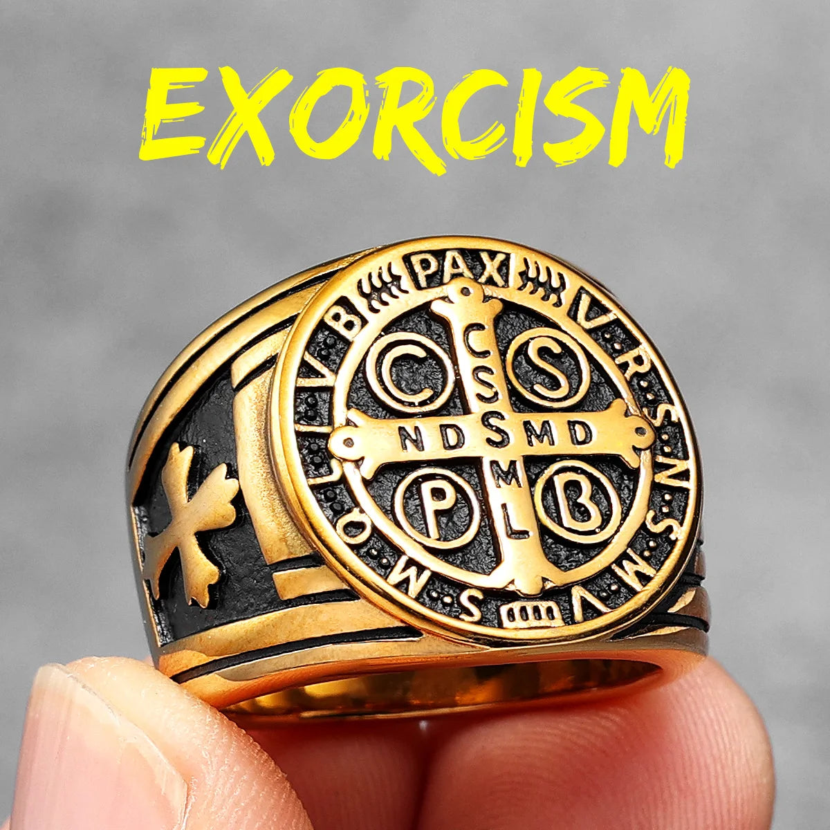 Gold ring with intricate designs held by a hand against a grey background, with 'EXORCISM' text above.