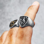 Silver ring with dragon design worn on a finger against a grey background
