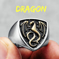 Gold ring with dragon design held between fingers against a grey background