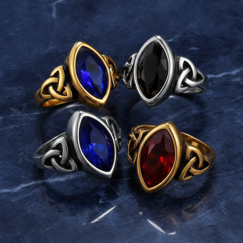 Four elven styled rings with coloured gemstones on a textured blue marble background