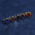 Elven styled rings with coloured gemstones lined together on a textured blue marble background
