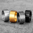 Four metallic rings in different colours on a textured surface