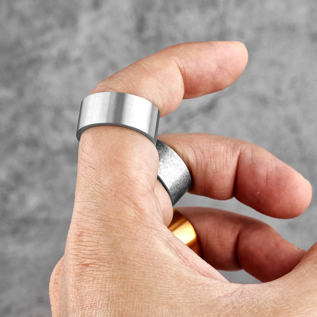 Hand wearing a silver ring with a blurred grey background