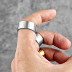 Hand wearing a silver ring with a blurred grey background