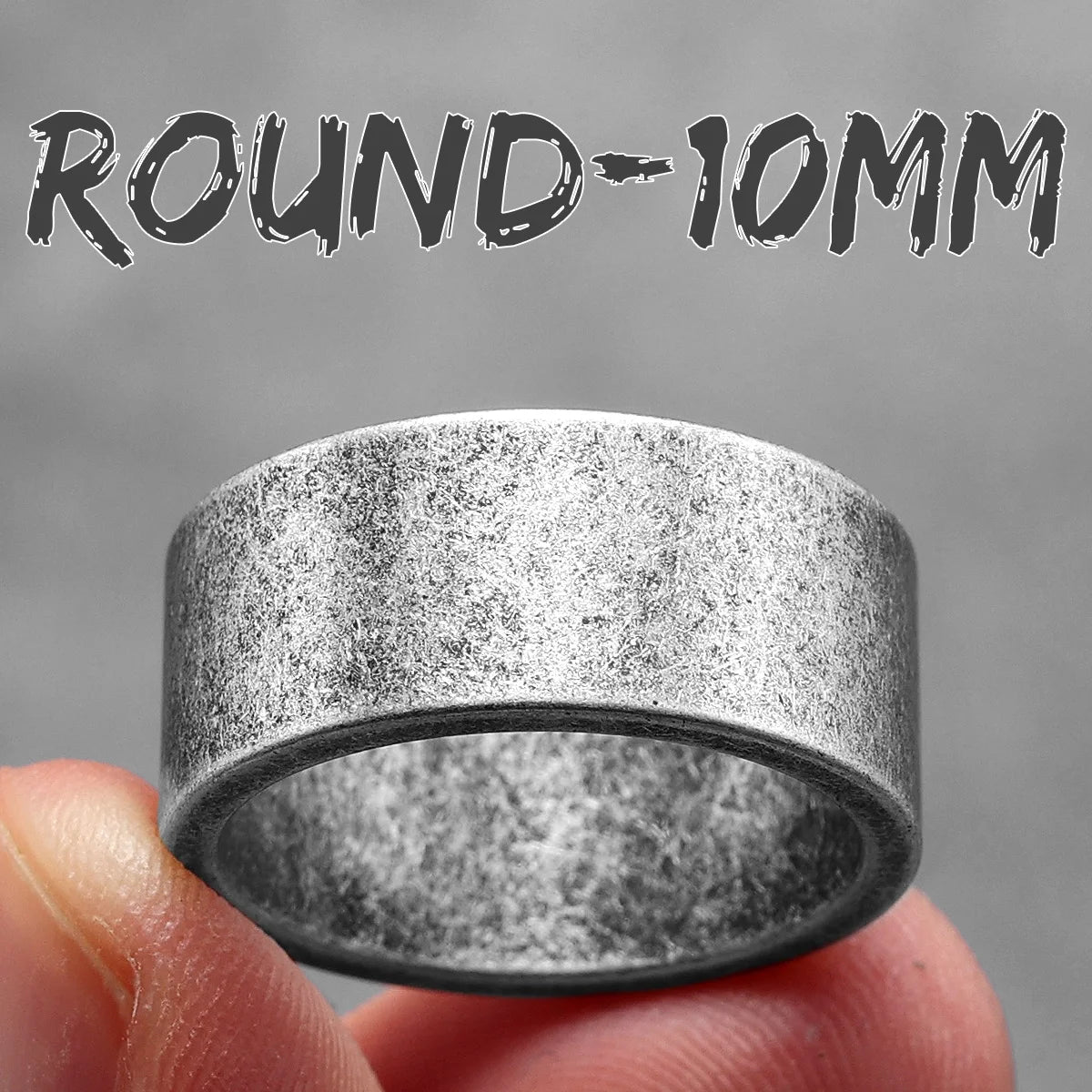 Round 10mm metal ring held between fingers with a grey background
