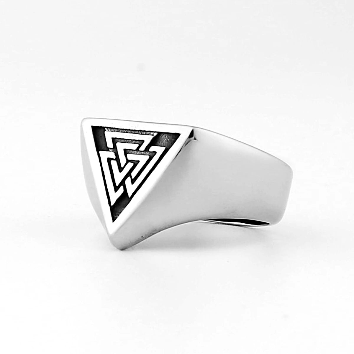 Silver ring with a geometric design on a white background