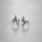 Pair of silver rings with a angel wing design on a light grey background