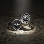 Two silver rings with star designs on an old map background with light shining down on it