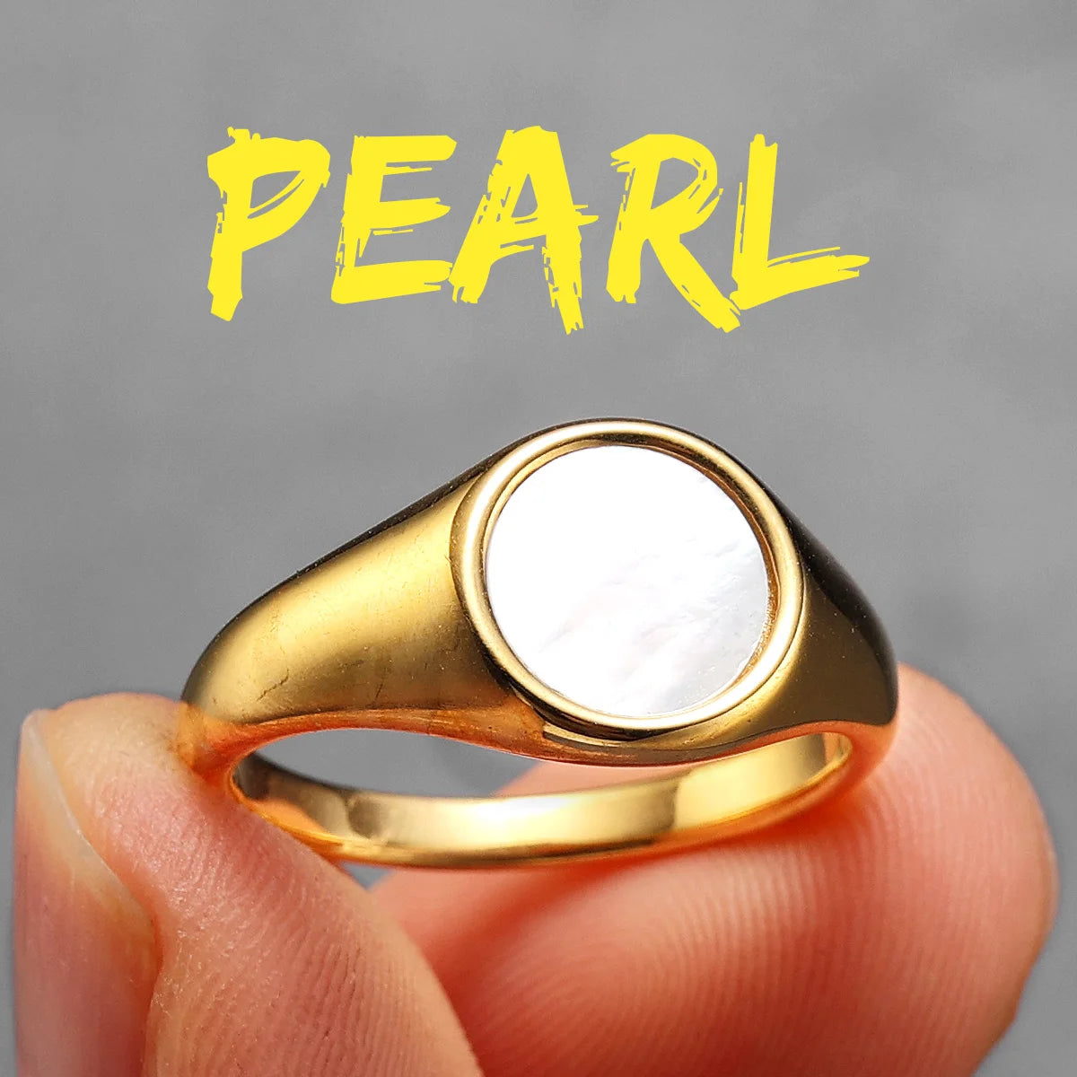 Gold ring with a pearl on a grey background with 'PEARL' text.