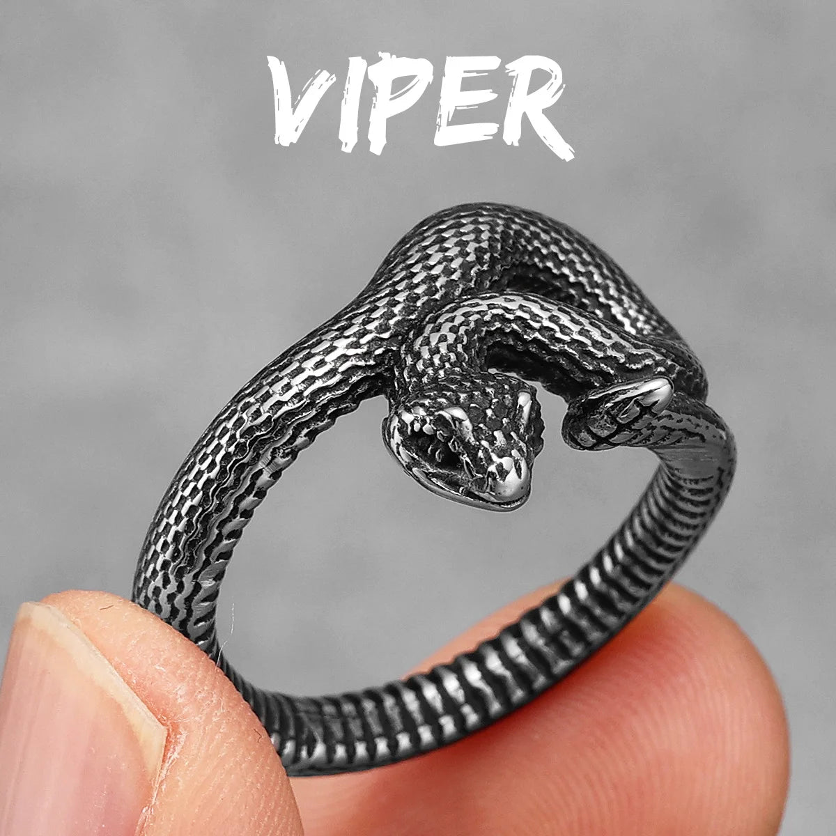 Silver snake-shaped ring held between fingers with 'Viper' text above on a grey background