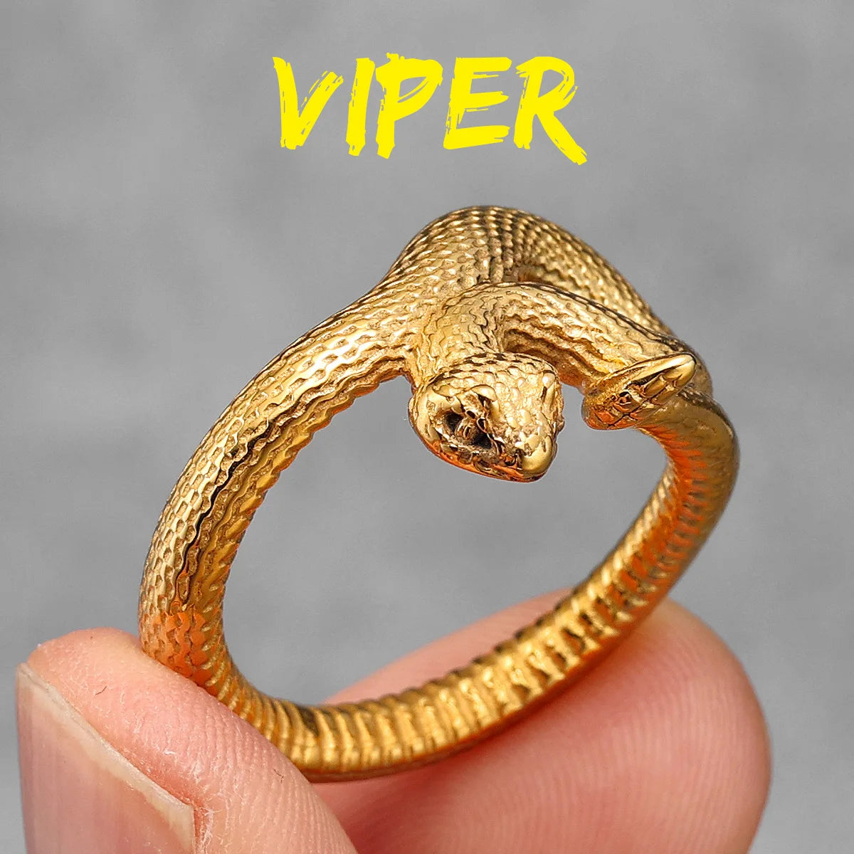 Gold viper-shaped ring held in a hand with a grey background and 'VIPER' text above.