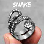 Silver snake-shaped detailed ring held in a hand with a grey background