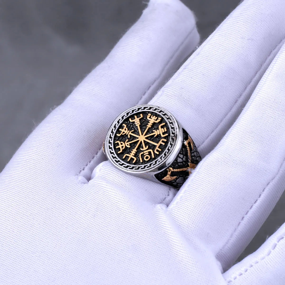 Silver ring with intricate Viking design on a white glove