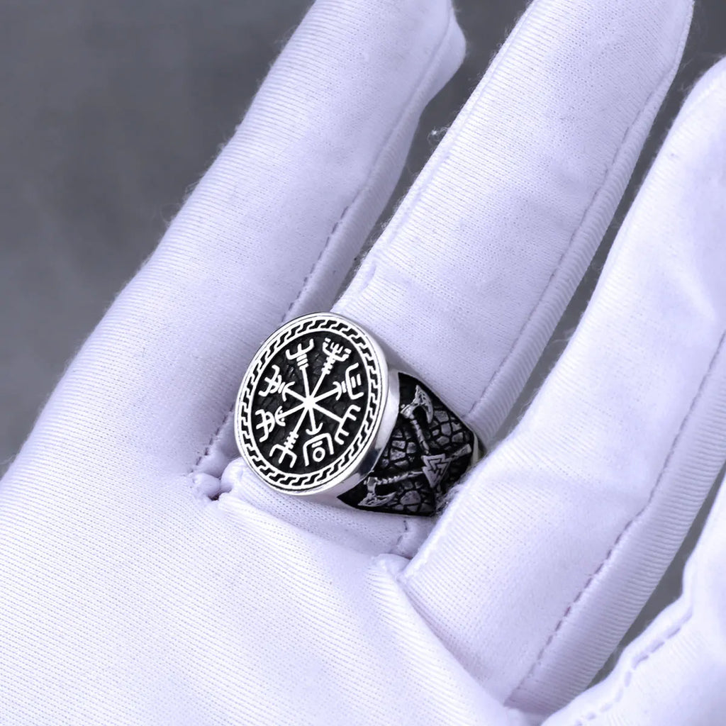 Silver ring with intricate Norse design on a white glove