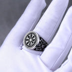 Silver ring with intricate Norse design on a white glove