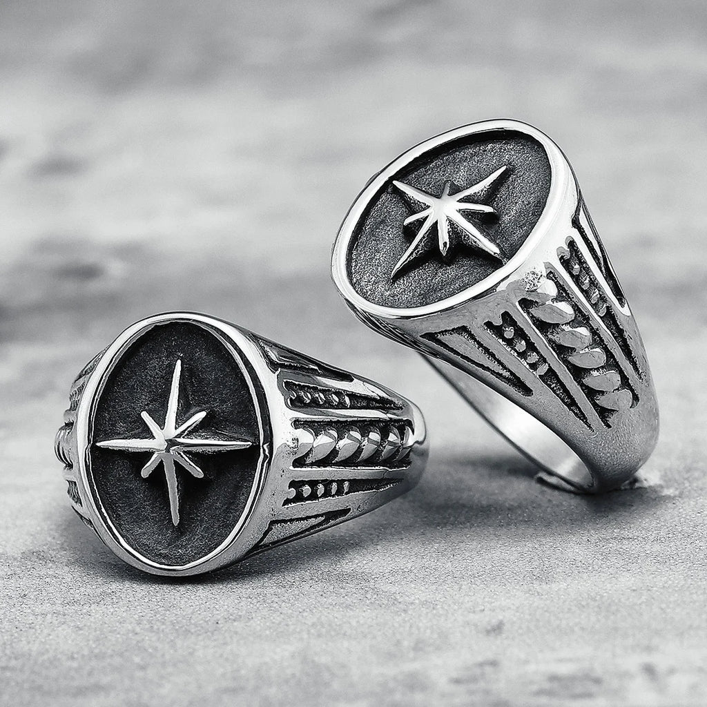 Two silver rings with star designs on a textured surface