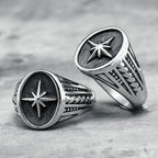 Two silver rings with star designs on a textured surface