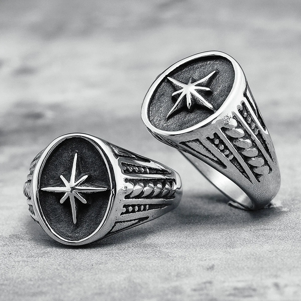 Two silver rings with star designs on a textured surface