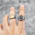 Two silver rings with star designs on a finger against a grey background