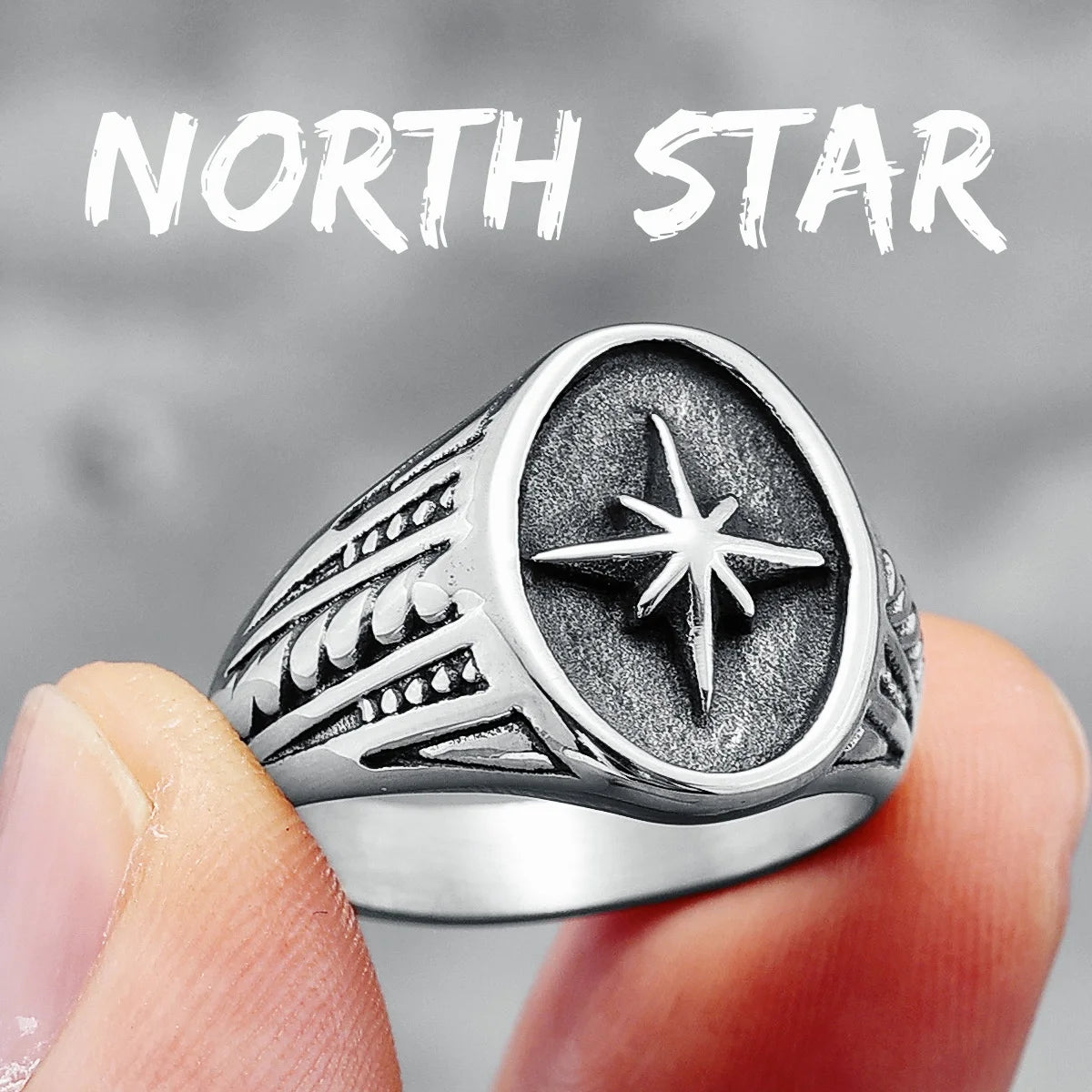Silver ring with star design held between fingers, 'North Star' text above.
