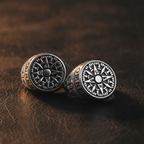 Two silver signet rings on a brown leather surface