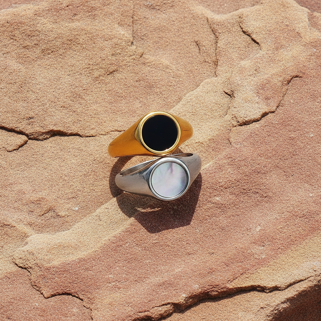 Two rings, one gold and one silver, on a textured sandstone surface