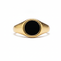 Gold signet ring with a black flat stone-like design on a white background