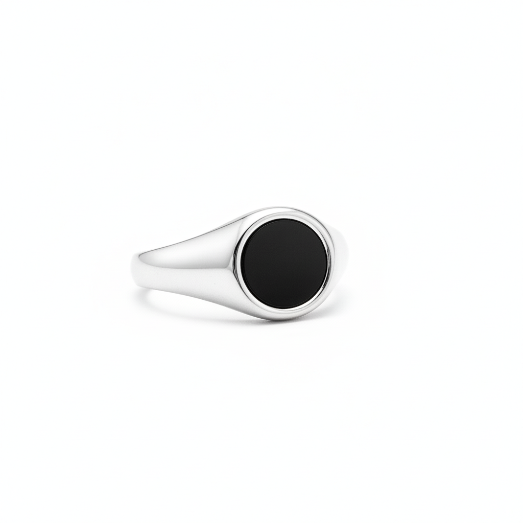 silver signet ring with black centre like a flat shell and pearl on a white background