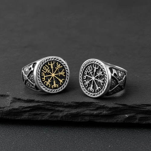 Two silver Viking signet rings with a intricate Vegvisir design on a charcoal coloured stone surface