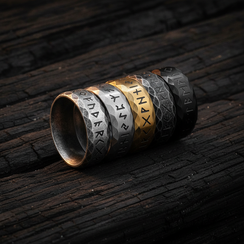 Stack of metal rings with engraved Viking runic text on a dark wooden surface