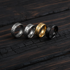 Runic and Norse styled rings sitting on a dark wood surface