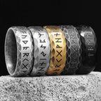 Set of five rings with engraved Viking runic symbols on a textured surface