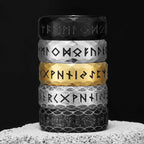Stack of five rings with Viking runes on a textured surface showing colours